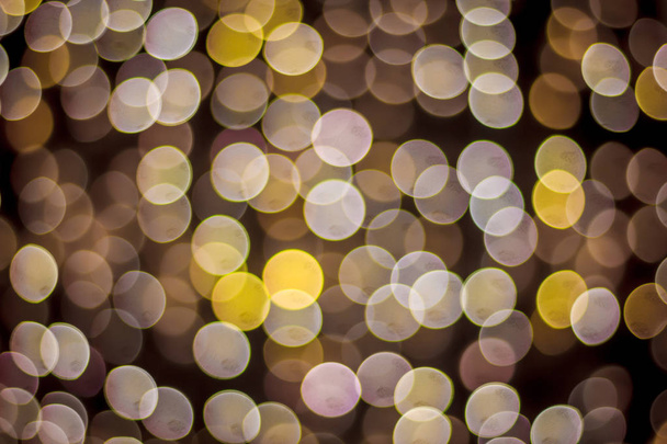 A festive Christmas background with a bokeh of Christmas tree lights. Blurred colored circles on a light holiday background - Photo, Image