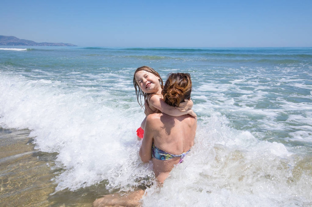 mère et enfant sautant des vagues dans la plage espagnole
 - Photo, image