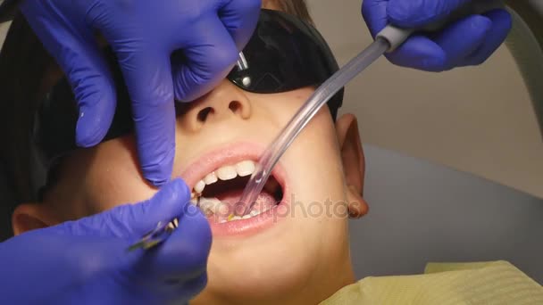 Child patient sitting on dental chair in paediatric dentists office - Video, Çekim