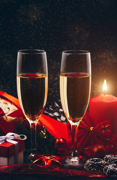 Christmas or New Year. Champagne in glasses with candles, panettone and gift with red satin bow. Copy-space. Holiday Concept - Foto, Imagem