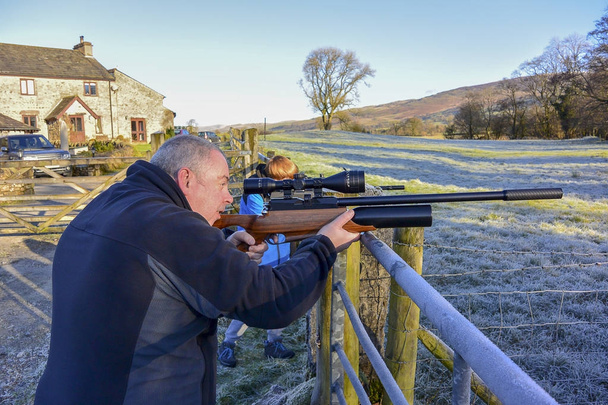Man and boy shooting with air rifle (landscape) - Photo, Image