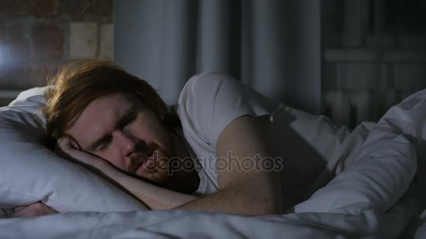 Niewygodne Ruda broda człowiek śpi w łóżku w nocy, niepokój - Materiał filmowy, wideo