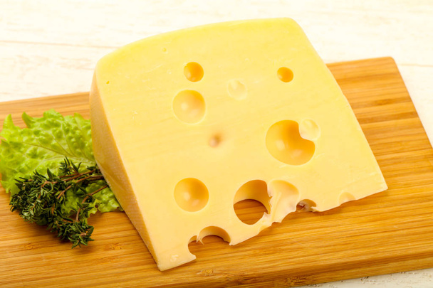 Ahşap plaka üzerinde peynir parçası - Fotoğraf, Görsel