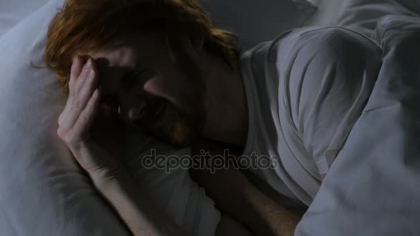 Baş ağrısı, depresif adam karanlık odada yatakta uyuyor - Video, Çekim