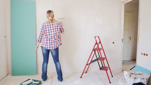 Beelden van gelukkig vrolijke vrouw dansen terwijl het doen van renovatie op Nieuw appartement - Video