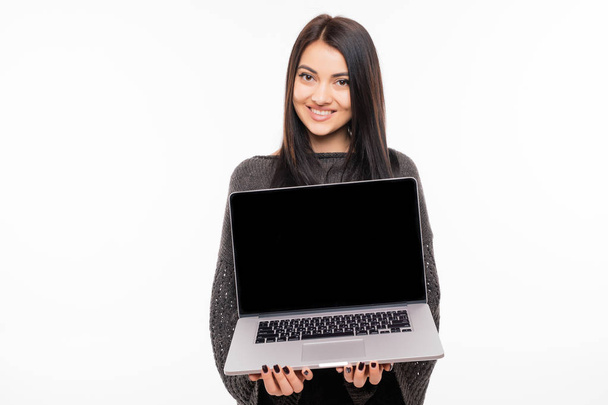 Laptop ayakta beyaz arka plan üzerinde kullanan genç kadın portresi - Fotoğraf, Görsel
