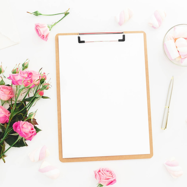 Beauty composition with marshmallow,  pink roses bouquet and clipboard on white background. Top view. Flat lay. Beauty blog, copy space - Photo, Image