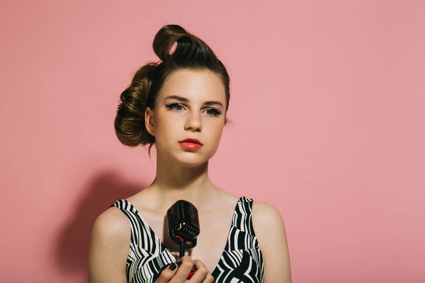 Pin up young girl on pink background, radio. - Foto, afbeelding