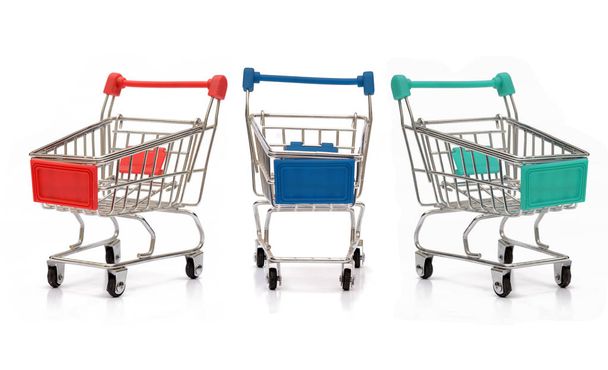 Verschillende kleuren Shopping Carts met reflectie op witte achtergrond - Foto, afbeelding