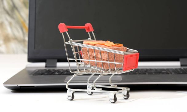 Alışveriş sepeti hediye paketi Laptop önünde ile online - Fotoğraf, Görsel
