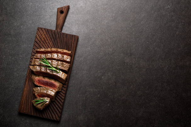 ローズマリーとスパイスでまな板の上のステーキ。焼き肉のレアステーキ - 写真・画像