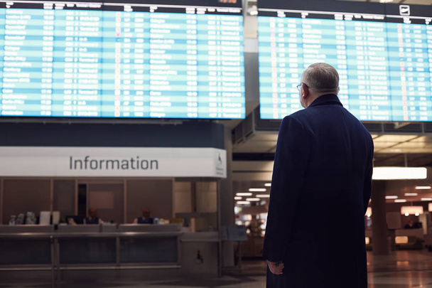 Man near airline schedule - Photo, Image