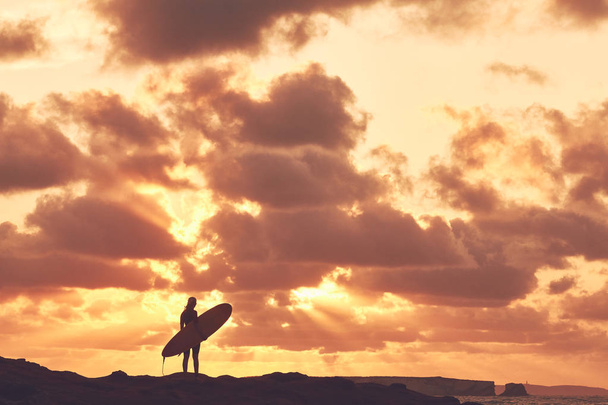 Surfer girl silhouet op zonsondergang - Foto, afbeelding