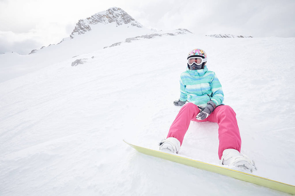 Genç oturan kadın snowboard ile - Fotoğraf, Görsel