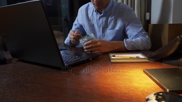 Un uomo mangia broccoli da un contenitore di cibo, lavorando su un computer portatile, a tarda notte, cibo sano, dieta. 4k
. - Filmati, video