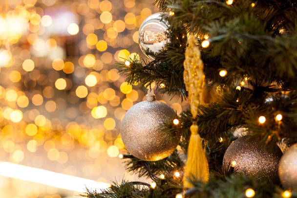 Decoraciones navideñas en abeto verde. Símbolos de las bolas de año nuevo y guirnaldas sobre un fondo amarillo borroso, bokeh
 - Foto, imagen