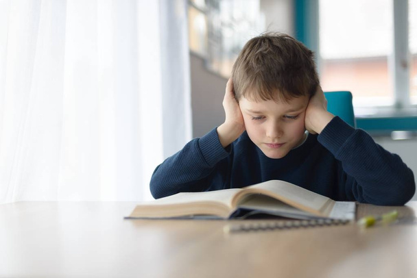 Kind liest ein Buch am Schreibtisch - Foto, Bild