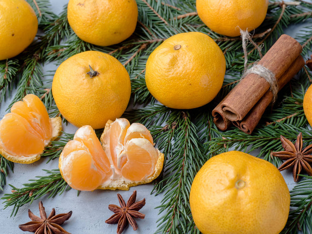 Fresh tangerines with branches of Christmas tree, star anise cinnamon on gray concrete background - Фото, зображення