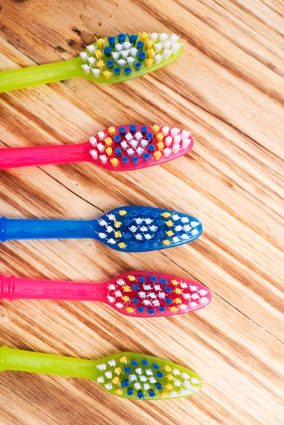 Escova de dentes de plástico colorida em fundo vintage de madeira
 - Foto, Imagem