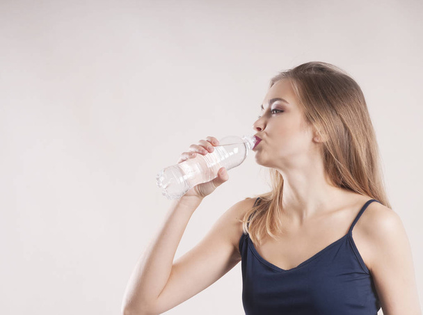 sporty girl with a bottle of water isolated - Photo, Image