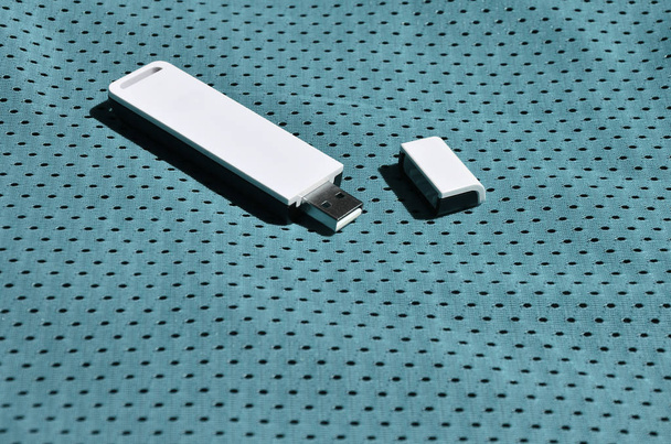 A modern portable USB wi-fi adapter is placed on the blue sportswear made of polyester nylon fiber - Φωτογραφία, εικόνα