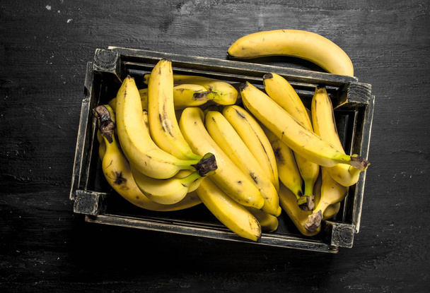 Ripe bananas in an old box. - Zdjęcie, obraz