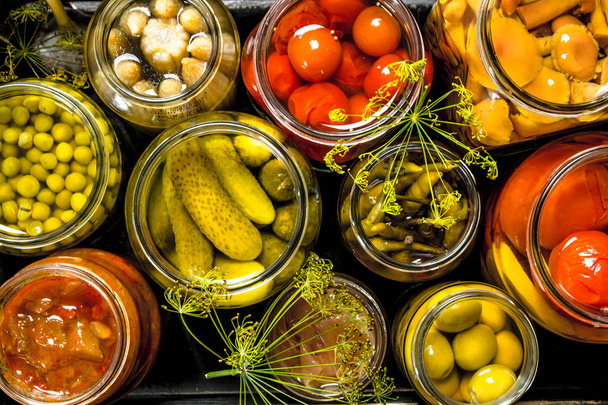 Preserves vegetables in glass jars in an old box. - Фото, зображення