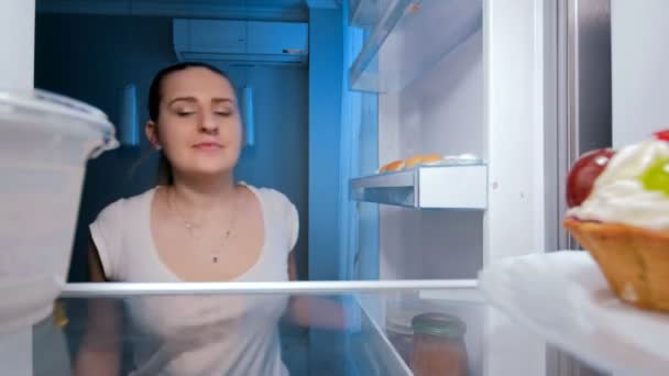 Imágenes de 4k de una mujer joven que toma mucha comida del refrigerador por la noche
 - Metraje, vídeo