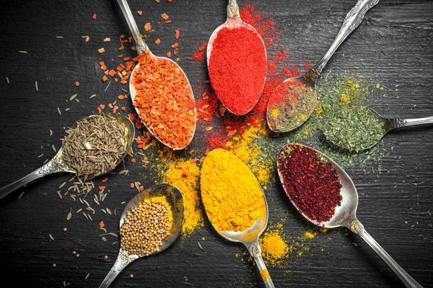 Ground spices and herbs in spoons. - Fotoğraf, Görsel