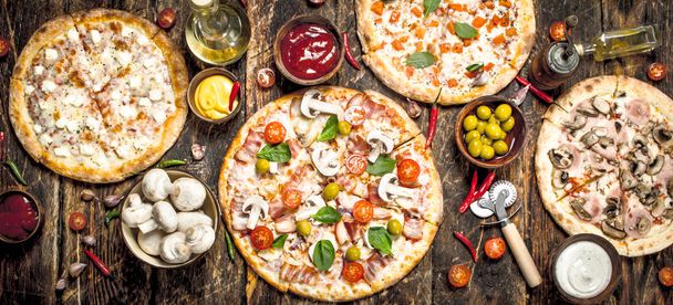 variety of pizzas. On wooden background - Foto, immagini