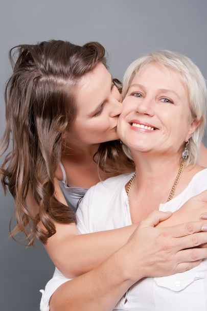 Playful Daughter kisses her Beautiful Mother on the cheek - Photo, Image