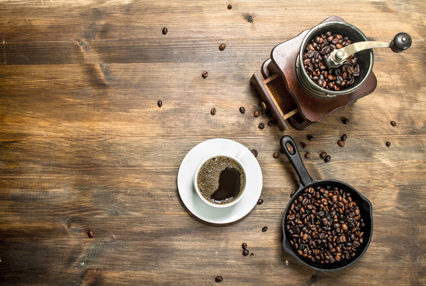 Fresh coffee in a cup with an old hand grinder. - Photo, Image