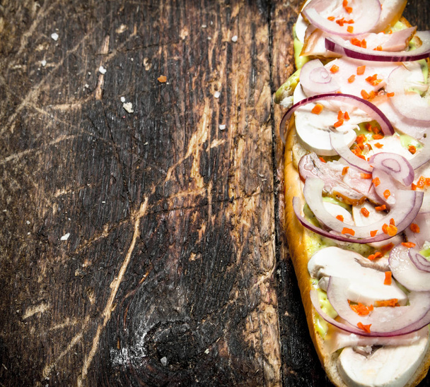 sandwich with mushrooms, ham and sweet onions on an old board. - Zdjęcie, obraz