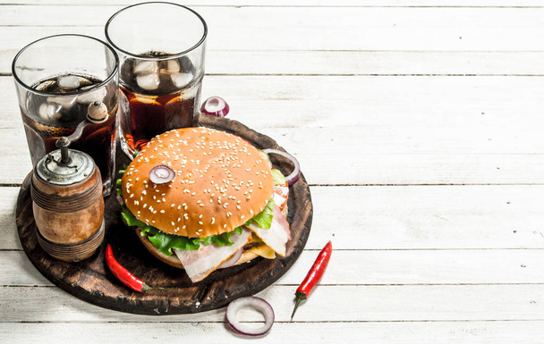 Fresh burger with cola on a wooden board. - Фото, зображення