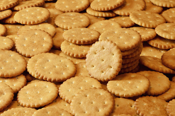 Closeup of salted crackers. Background image of classic salty cracker on a brown wooden table - Photo, Image