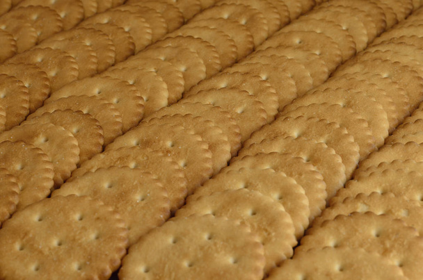 Close-up van gezouten crackers. Achtergrondafbeelding van klassieke zoute kraker op een bruin houten tafel - Foto, afbeelding