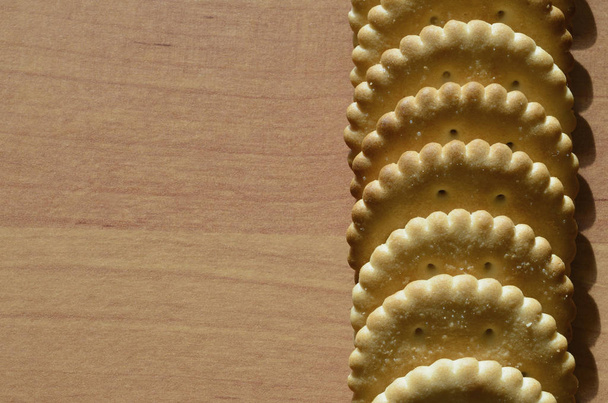 Imagen de fondo de la galleta salada clásica sobre una mesa de madera marrón con copyspace
 - Foto, imagen