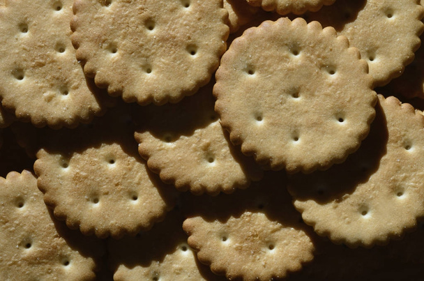 Closeup slané krekry. Obrázek pozadí klasické slanou sušenku na hnědý dřevěný stůl - Fotografie, Obrázek