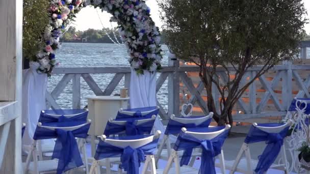 Festive atmosphere in the vicinity of the provincial town.Locations of the wedding ceremony.Pictures from the wedding ceremony.It 's windy on the river.Requisites of the wedding ceremony.Dolly of rows of chairs at a wedding ceremony from the aisle
. - Кадры, видео