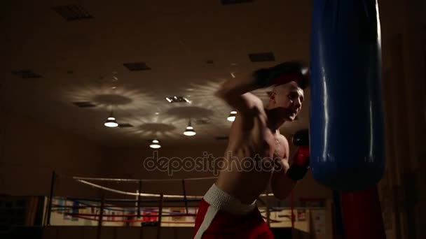 Strong blows to the pear in boxing gloves deal a strong man. - Filmati, video