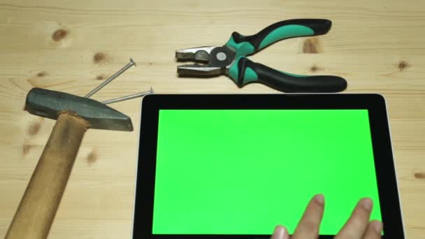 修理とタブレット用ハンドツール。ペンチ、ハンマー、緑のディスプレイを搭載したタブレット. - 映像、動画