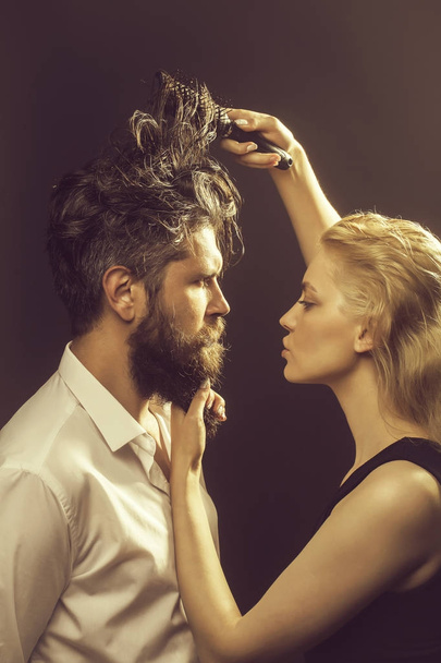 blonde hairdresser combing bearded man - Foto, Bild