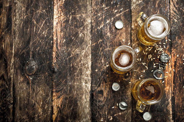 Birra fresca in un bicchiere con tappi e apribottiglie
. - Foto, immagini
