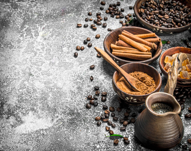 Fresh coffee in a clay turkey with crystals of sugar and cinnamon. - Photo, Image