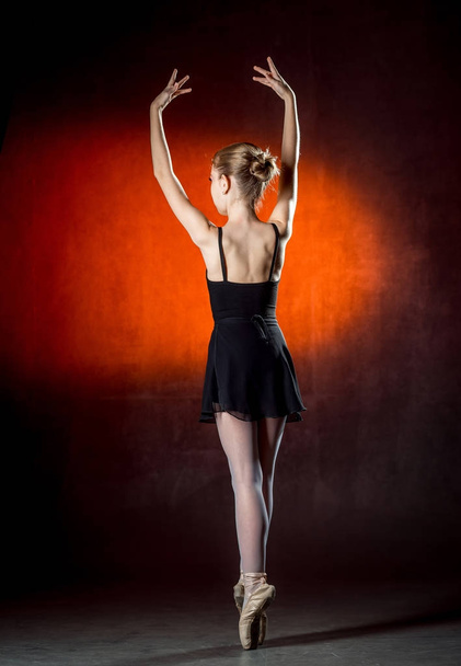 Ballet. Image of a flexible cute ballerina dancing in the studio. Beautiful young dancer. A ballerina is posing. - Photo, image