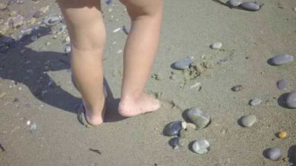 kum deniz kıyısı üzerinde oynayan küçük bir çocuk bacaklar - Video, Çekim