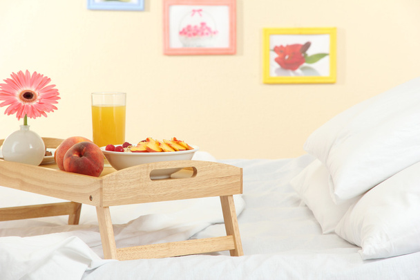 wooden tray with light breakfast on bed - Fotoğraf, Görsel