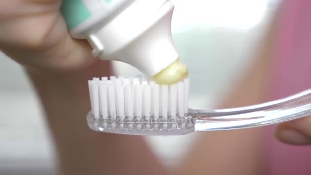 Wyciskanie pasty do zębów z tubki na szczoteczkę do zębów. Makro, szczegół 4k. zwolnionym tempie, miejsce - Materiał filmowy, wideo