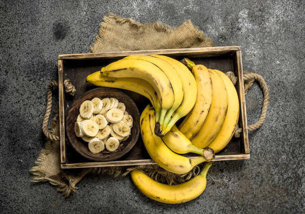 Pieces of fresh bananas in a bowl on a tray. - Zdjęcie, obraz
