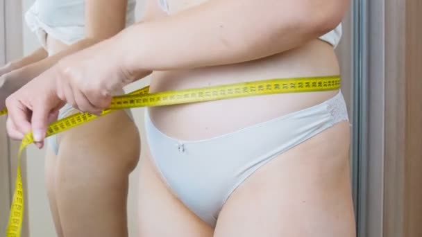4k video de mujer joven midiendo la cintura con cinta métrica amarilla
 - Imágenes, Vídeo
